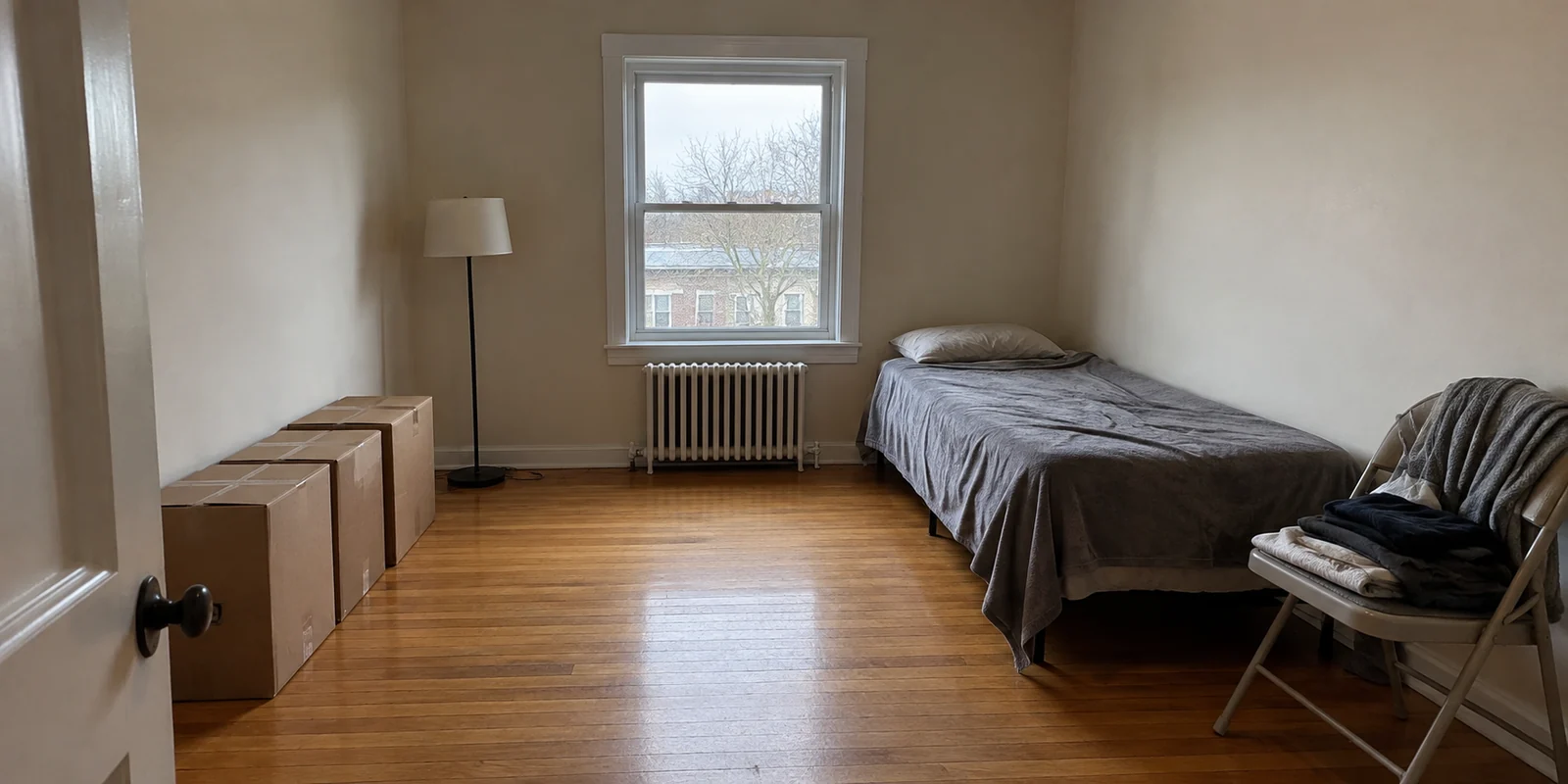 The same spare room before redesign, with a bed and storage boxes